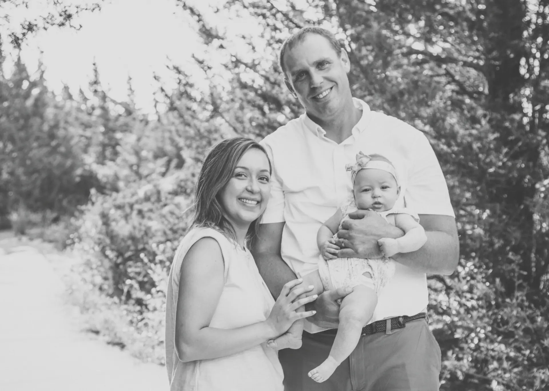 Black and white portrait of new parents holding their baby girl
